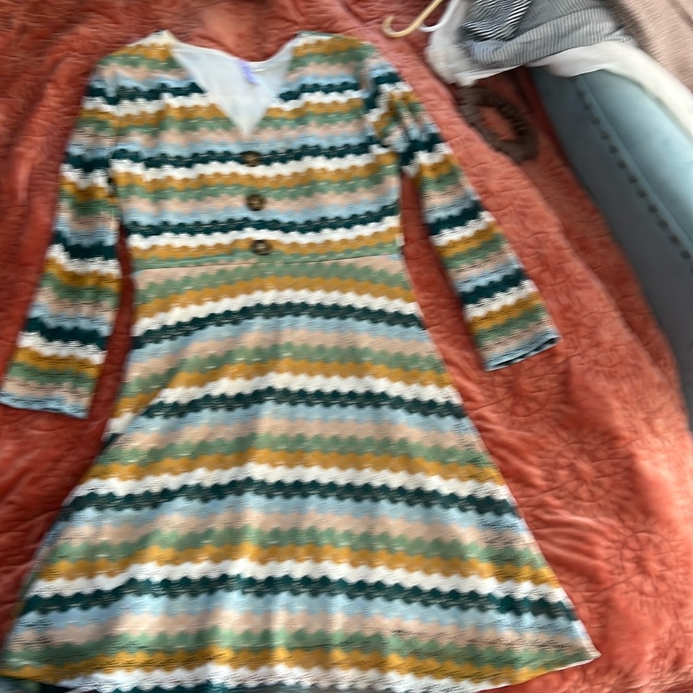 Adorable 70’s style mini dress with button detail and sheer sleeves.